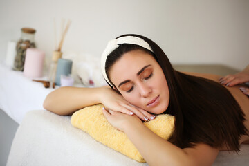 Obraz na płótnie Canvas Attractive girl enjoying a facial massage in a spa