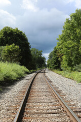 Obraz premium Railroad tracks heading into dark stormy sky