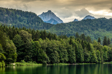 Beautiful view over the lake called Alpsee next to the castle Neuschwanstein and Hohenschwangau in Bavaria, Germany at a cloudy day in summer.