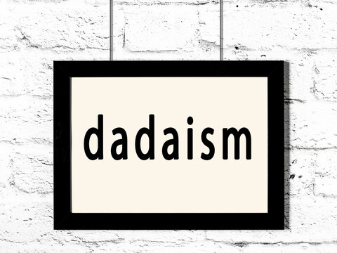 Black Frame Hanging On White Brick Wall With Inscription Dadaism