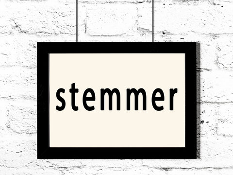 Black frame hanging on white brick wall with inscription stemmer