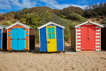 Rows of multi-coloured beach huts along Saunton Sands in North Devon, UK