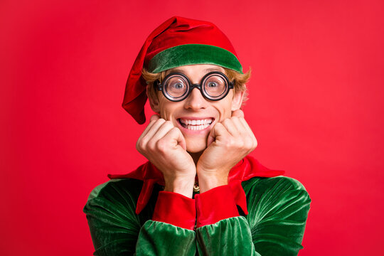 Portrait of funky elf guy touch fists cheeks x-mas present wait concept wear geek style specs isolated on red color background