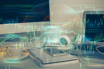 Double exposure of graph and financial info and work space with computer background. Concept of international online trading.