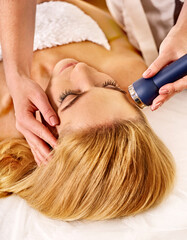 Naklejka premium Ultrasound massage and therapy in cosmetology phonophoresis by woman in spa salon.