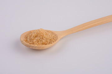 brown sugar in a wooden spoon isolated on white