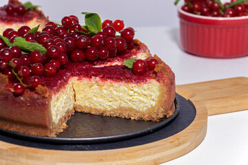 Cheesecake with red currant and mint on wooden board. Top view.