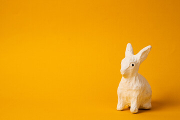 White Easter bunny on a yellow background animal decoration Copy Space