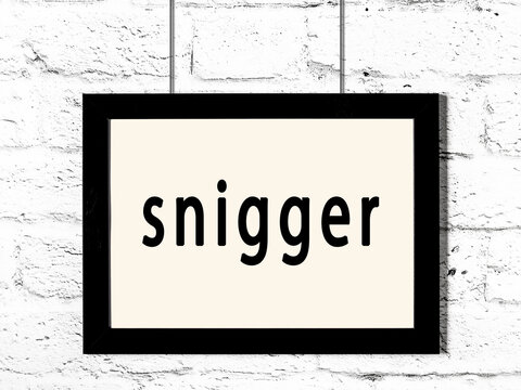 Black frame hanging on white brick wall with inscription snigger