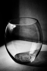 Beautiful photo of a glass vase, abstract glass texture. Sylanna round vase, standing at the window, still life of decoration. Black and white photography, black and white style with high contrast