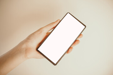 Woman hand holding smartphone with white screen. Female hand demonstrating new smartphone with blank screen.