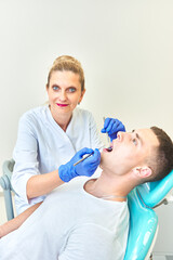 dentist doctor examines the mouth of a young guy. man at the stomatologist