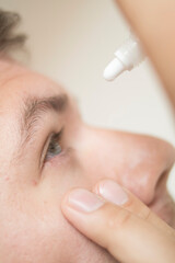 Naklejka premium Guy drips his eyes with drops