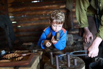 Child learning to work with hammer