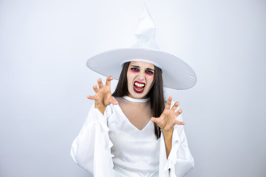 Woman Wearing Witch Costume Over Isolated White Background Smiling Funny Doing Claw Gesture As Cat, Aggressive And Sexy Expression