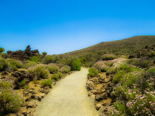 Sendero, monta&ntilde;a y cielo azul: Un paisaje ideal por el que caminar en verano.