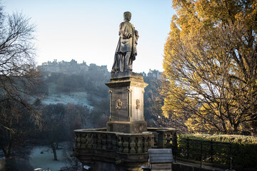 Fototapeta premium Statue in Princes Street Gardens, Edinburgh, during autumn – yellow leaves, Scotland travel, historical landmark