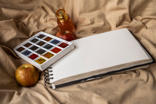 Paint and notebook with apple
