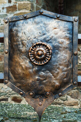 Medieval antique metal shield, with a textured surface.