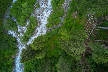 Alps italy panorama mountain torrent. Beautiful view of mountain river in summer. Aerial view. Fallen tree into the river. Mountain river in the alps.