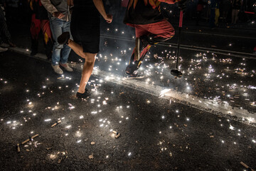 Correfoc. People dancing at night with fire sparks among their feet in a popular tradition in...
