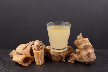 Bone broth in glass. Dark background, copy space. Beef bones contain natural collagen, which provides the body with amino acids, which are the building blocks of proteins
