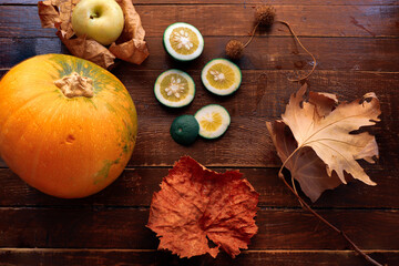 Autumn composition; Apple, pumpkin and fallen leaves on wooden background. Halloween, Thanksgiving or seasonal autumn. Design fitting. Horizontal