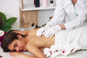 Obraz na płótnie Canvas back massage.Young beautiful european woman sleeping relaxing on oil spa massage in salon.