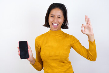 Young hispanic girl with short hair wearing casual yellow shirt isolated over white background...
