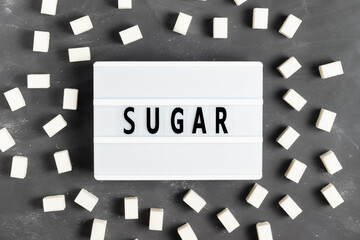 Sugar lettering on a white board on a gray background with sugar cubes for World Diabetes Day November 4