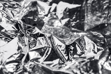 Texture of a thin crumpled sheet of foil. Crumpled foil background. Stock photo shiny foil. Silver chrome color. copy space.