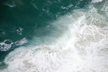Fototapeta na wymiar Abstract wild coast line with sea foam and crashing waves shot from above. Birdseye/aerial view. Shot in South Africa.