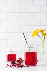 Fresh pomegranate juice in a glass jar on a marble surface with copy space