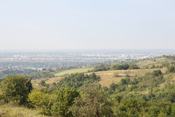 Fototapeta na wymiar Aerial panoramal of Novi Sad, seen from a hill of Fruska Gora National park during a summer afternoon. Novi Sad is the capital city of Vojvodina and a major place in Serbia