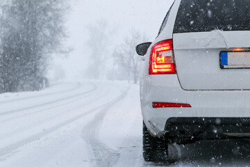 Car on country Winter, snow, poor visibility on the road. Car during a snowfall on the road with the headlights