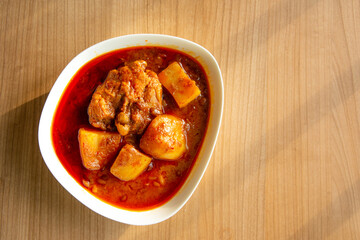 Thai Chicken massaman curry in warm light - Thai chicken and potato curry in coconut milk and herb eat with white rice