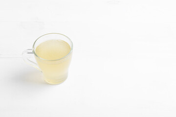 Homemade bone broth with leek in glass cup
