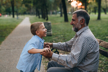 boy playing with his granddad in the city park