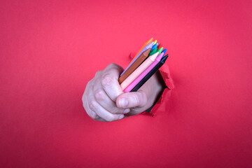 Colored pastel crayons in hand. Kindergarten, education, art and creativity concept
