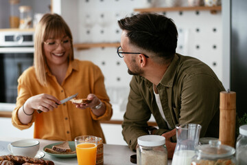 Young couple making delicious food at home. Loving couple enjoying in the kitchen..