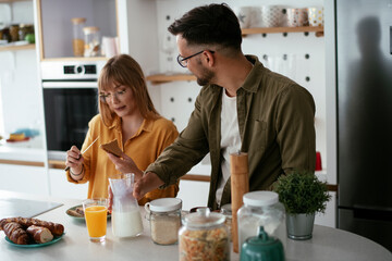 Young couple making delicious food at home. Loving couple enjoying in the kitchen..