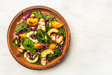 Healthy salad. Buddha bowl dish with chicken fillet, purple cabbage, avocado, spinach, tomatoes and nuts on a light background. Healthy balanced eating. space for text. top view