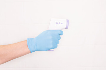 Doctor is holding a digital infrared thermometer on white background