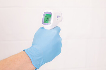 Doctor is holding a digital infrared thermometer on white background