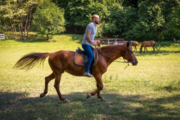 Young man galloping on a horse during midday
