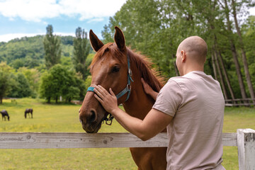 Young man bonding with a horse at the ranch