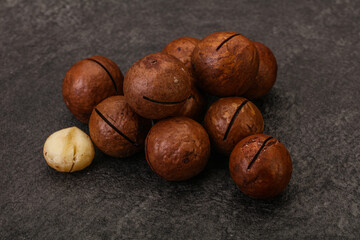 Brown macadamia nut heap over background
