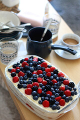 Tiramisu cake, decorated with berries, served on a table. Selective focus.