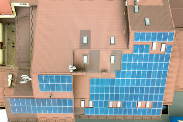 Aerial view of solar power plant with blue photovoltaic panels mounted of apartment building roof.