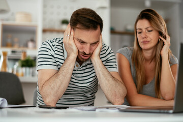 Husband and wife preparing bills to pay. Young couple having financial problems.